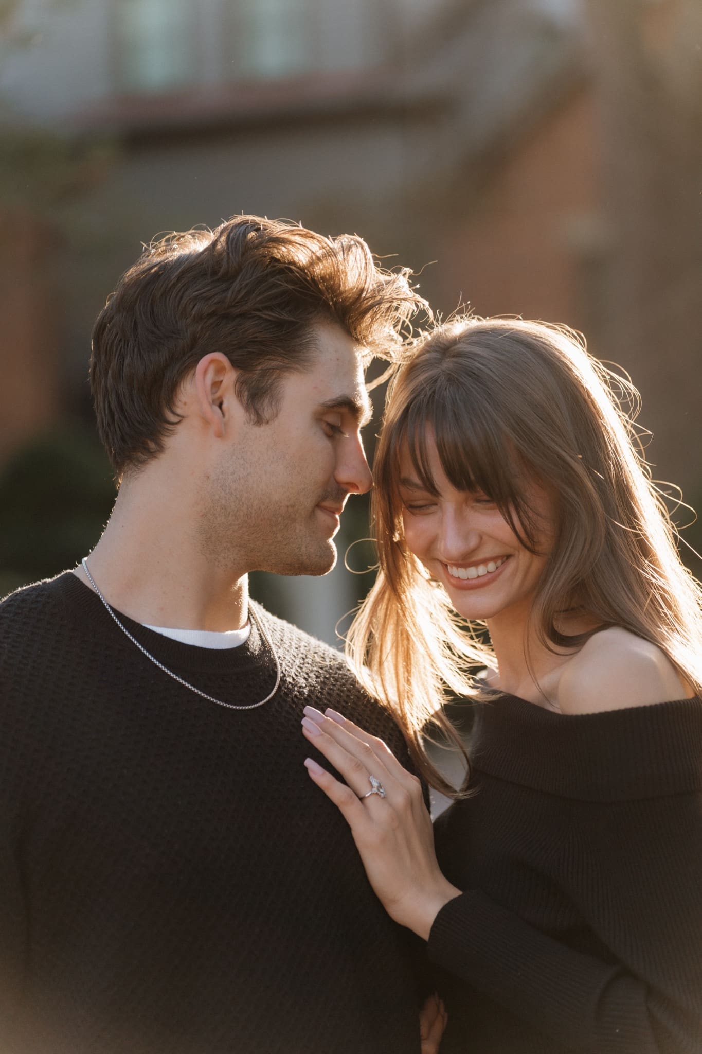 Engagement ring on her hand as she rests it on her fiancé's chest, golden hour in Columbus, Ohio