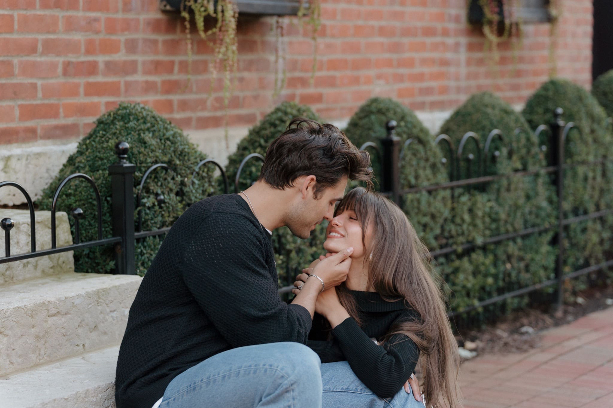Couple sitting on stone steps beside an iron fence near Frank Fetch Park in German Village, Columbus